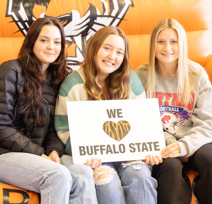 Three students holding a sign