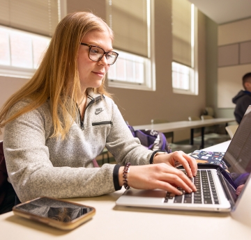 HEA student in class with a laptop