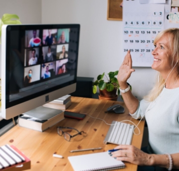 Woman holding her hand up in an online meeting