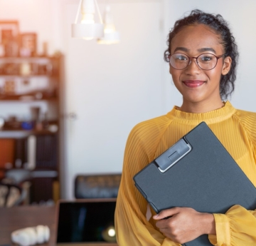 Smiling young woman holding a clipboard