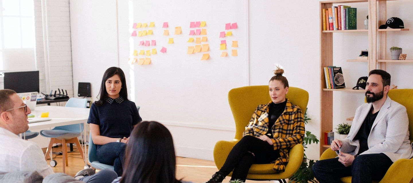 Group of men and women talking around coffee table